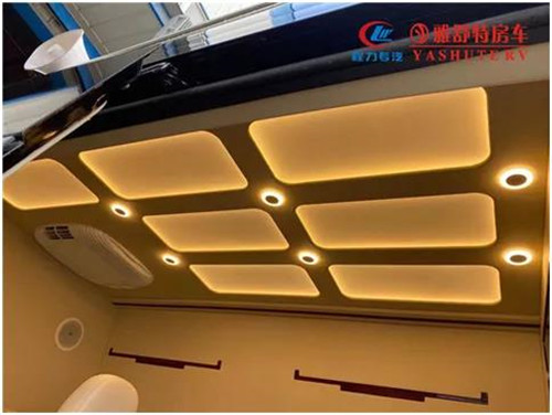 內(nèi)部車頂：采用帶造型的正白 LED 燈箱作為主照明系統(tǒng)，四角設(shè)計(jì)有帶獨(dú)立開關(guān)的裝飾射燈，嵌入式裝配工藝，便于后期檢修維護(hù)。車內(nèi)照明系統(tǒng)偏向于簡(jiǎn)潔、實(shí)用、明亮、整齊的現(xiàn)代辦公氛圍，LED 射燈指向光源和立柱壁燈，對(duì)整個(gè)辦公區(qū)照明，整車 內(nèi)部氛圍襯托均予以兼